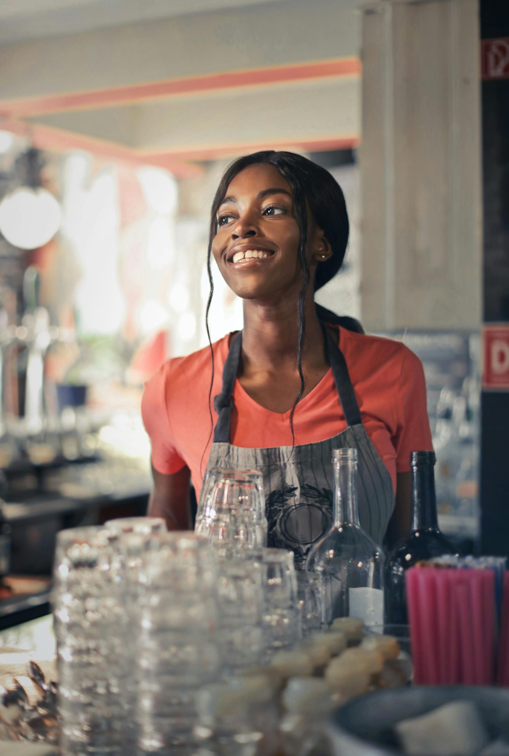 A cheerful bartender in a vibrant bar setting, showcasing hospitality and service.